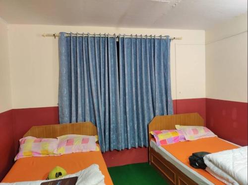 two beds in a room with a window at Marpha appleland hotel and suite in Tukucha