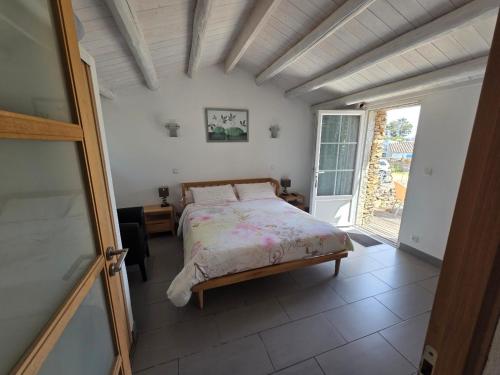 a bedroom with a bed and a large window at Chambres d'hôtes - Chez Stephane in L'Ile d'Yeu