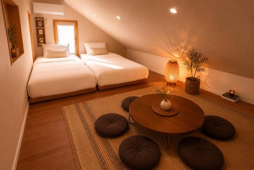 a bedroom with two beds and a table and a bed at On Stay - Hotel Quality Stay in Seoul