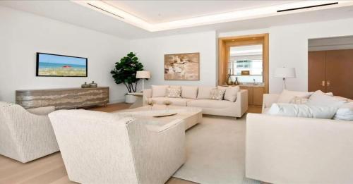 a living room with white furniture and a fireplace at Naples Luxury Retreat in Naples