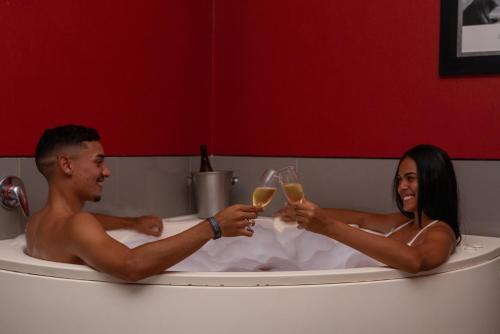 a man and woman sitting in a bath tub with wine glasses at Vila Galé Resort Cumbuco - All inclusive in Cumbuco