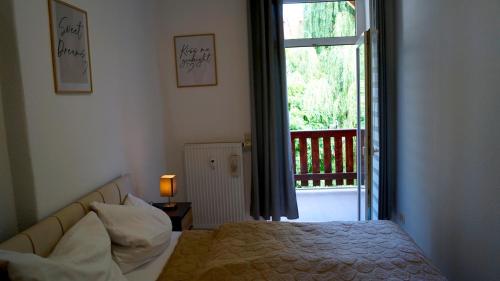 a bedroom with a bed and a large window at Apartment 24 modern & gemütlich in Dessau