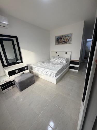 a white bedroom with a bed and a mirror at Chalet in Blumar Ain soknha in Ain Sokhna