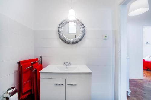 a bathroom with a white sink and a mirror at Casa da Avenida in Cascais
