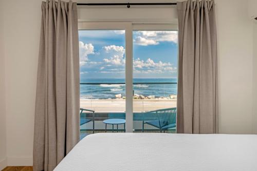 a bedroom with a bed and a view of the ocean at Ocean Surf at York Beach in York