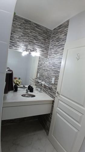 a bathroom with a sink and a mirror at Marce's house in General Roca