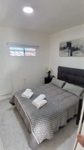 a bedroom with a bed with two white towels on it at Marce's house in General Roca