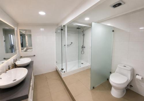a bathroom with a shower and a toilet and a sink at Hotel Carande, Papudo in Papudo
