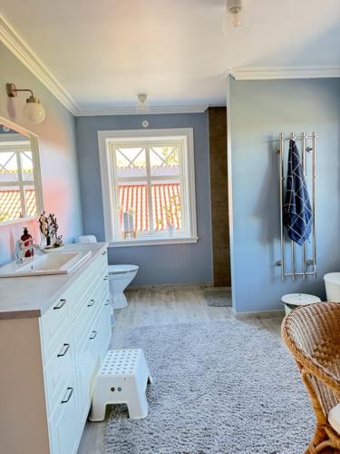 a bathroom with a sink and a toilet and a window at Naturskönt boende nära sjö in Ör