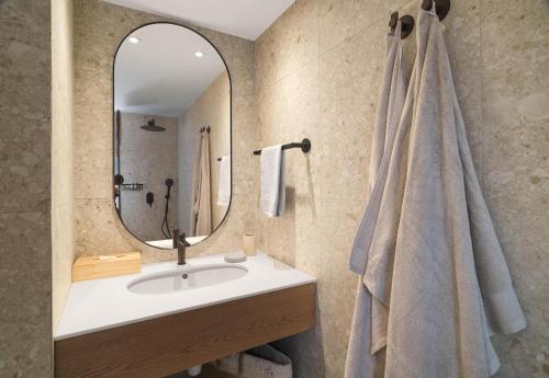 a bathroom with a sink and a mirror at Villa Akroyiali - Seafront Serenity with Shared Pool in Pachyammos