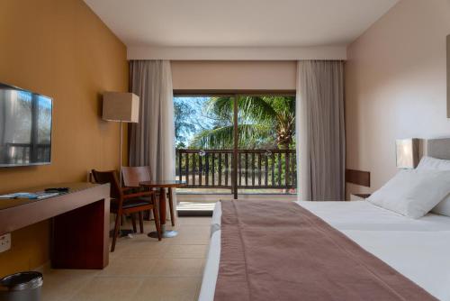 a hotel room with a bed and a balcony at Vila Galé Resort Cumbuco - All inclusive in Cumbuco