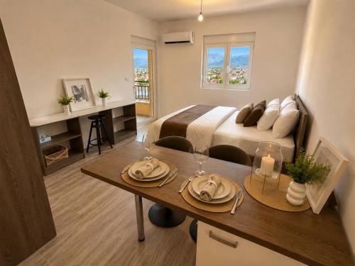a bedroom with a bed and a table with plates on it at Alula Apartments 2 in Bar