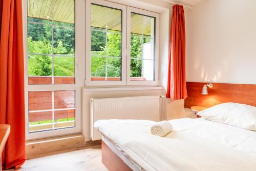 a bedroom with two beds and a large window at Hotel Velveta in Špindlerův Mlýn