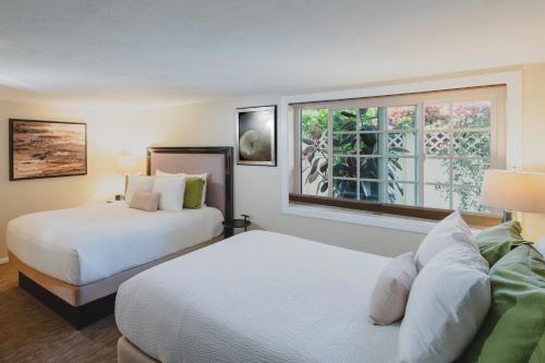 a hotel room with two beds and a window at Coast Village Inn in Santa Barbara