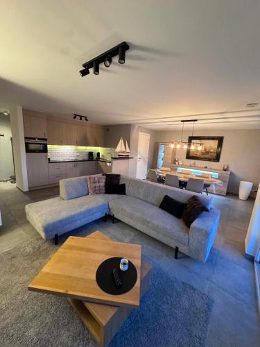 a living room with a couch and a table at L'Appart de Grand-Père in Oudenburg
