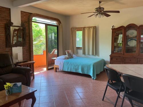 a bedroom with a bed and a living room at Casitas Las Palmas - La Brisa in Punta Mita