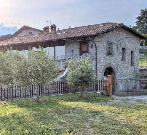an old stone house with a wooden fence at Corte Furmignano in Solto Collina