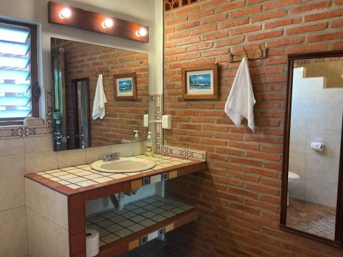 a bathroom with a sink and a brick wall at Casitas Las Palmas - La Brisa in Punta Mita