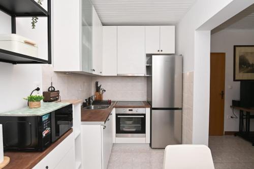 a kitchen with white cabinets and a stainless steel refrigerator at Brko's Place Sinj in Sinj