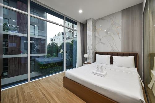a bedroom with a large bed and a large window at The Crown Airport Hotel in Ho Chi Minh City