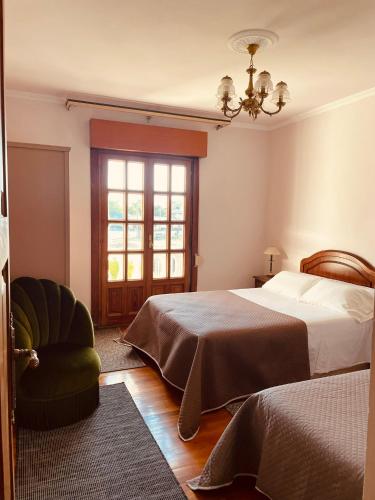 a bedroom with a bed and a chair and a window at Villa Horta in Horta