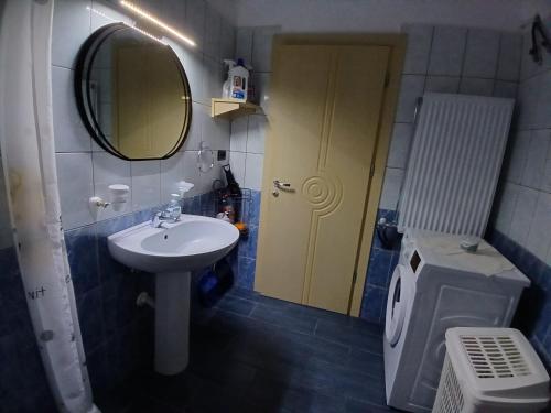 a bathroom with a sink and a mirror and a toilet at EniGuesthouse in Gjirokastër