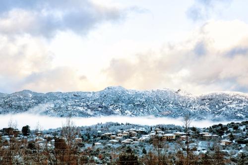 a city covered in snow with mountains in the background at Nymfasia Resort in Vytina