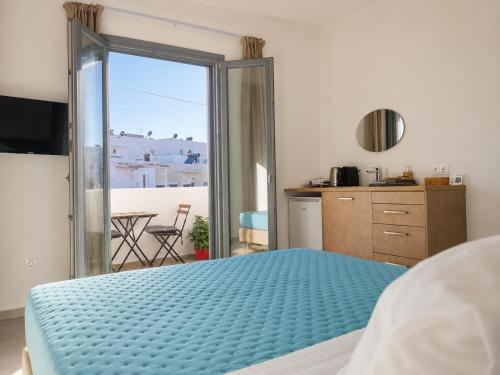 ein Schlafzimmer mit einem blauen Bett und einem Balkon in der Unterkunft Aqualis in Adamas
