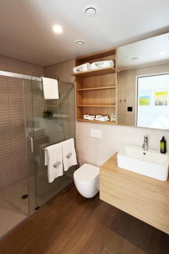 a bathroom with a toilet and a sink and a shower at Cormorant Rock Chalets in Ingonish Beach