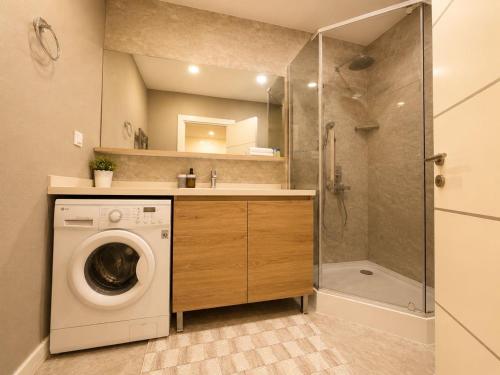 a bathroom with a washing machine and a shower at Bishkek Park Apartments in Bishkek