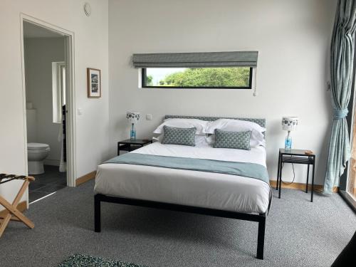 a bedroom with a bed with two pillows and a window at Craighall Steading B&B in Ceres