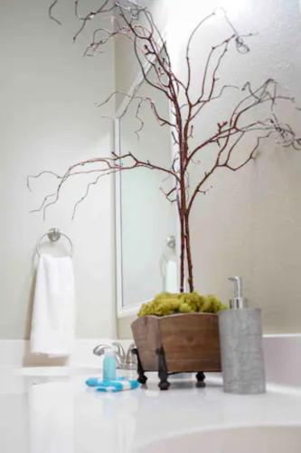 a bathroom sink with a tree in a bath tub at Ground Floor, 3BR Sleeps 8, Near Ingalls and Chevron -F- in Moss Point