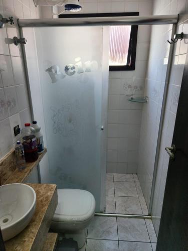 a bathroom with a shower with a toilet and a sink at Apto Sol Nascente in Mongaguá