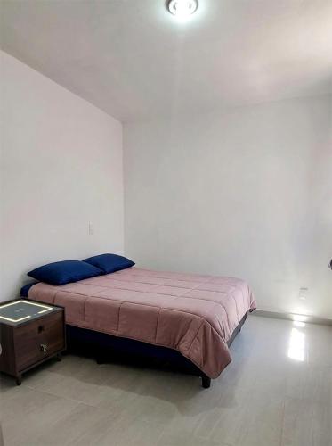 a bedroom with a bed with a nightstand and a bed sidx sidx sidx sidx at Casa Las Luces in Nanacamilpa