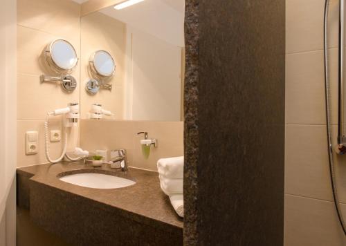 La salle de bains est pourvue d'un lavabo et d'un miroir. dans l'établissement Villa Bergzauber, à Rossleithen