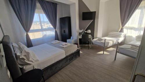 a bedroom with two beds and a chair and a window at U Baruni B&B in Messina