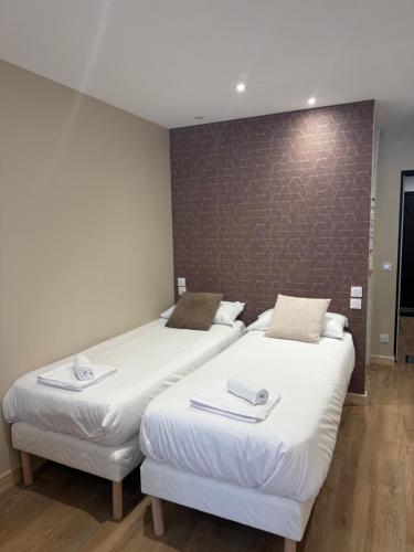 two beds sitting next to each other in a room at Le Col Getaway Virage 6 in Le Bourg-dʼOisans