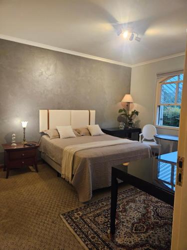 a bedroom with a bed and a table and a window at Mansão Morumbi 91 in São Paulo