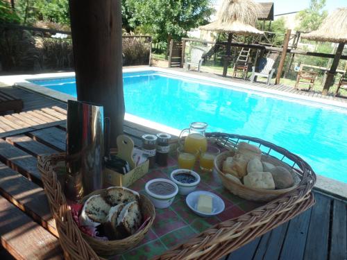 a table with food and drinks next to a swimming pool at Cabañas Peumayen in Colón