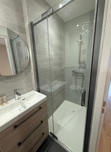 a bathroom with a glass shower and a sink at Le Col Getaway Virage 6 in Le Bourg-dʼOisans