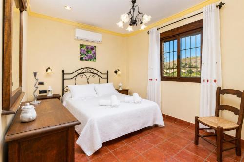 a bedroom with a bed and a table and a chair at Villa Las Palomas 2 in Nerja
