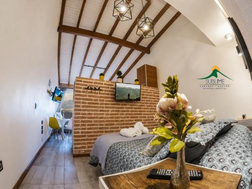 a bedroom with a bed and a brick wall at Cabañas Sublime Bolson in El Bolsón