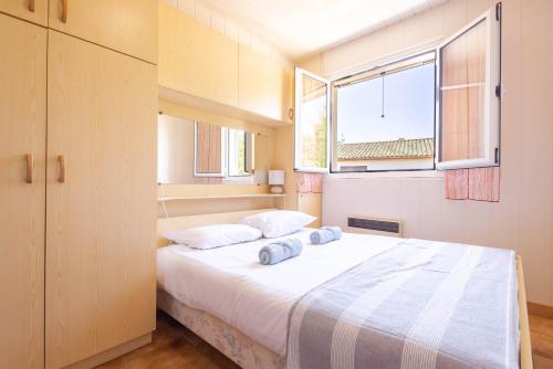 a bedroom with a bed with two pillows on it at La Brise de Valras in Valras-Plage