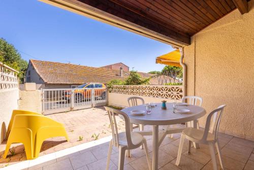 a patio with a table and chairs on a balcony at La Brise de Valras in Valras-Plage