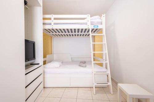 a room with a bunk bed and a tv at Charme et Confort A vnedres in Vendres