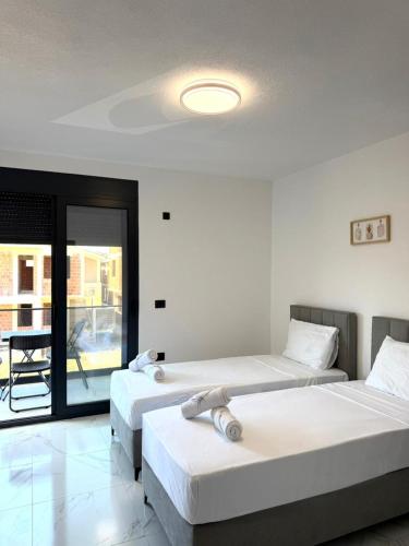 two beds in a room with a balcony at Raba Apartments in Donji Štoj