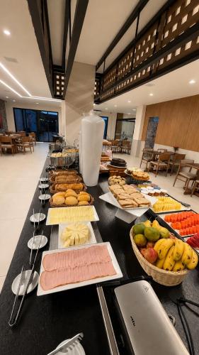 a table with many different types of food on it at Bristol Exceler Campo Grande in Campo Grande