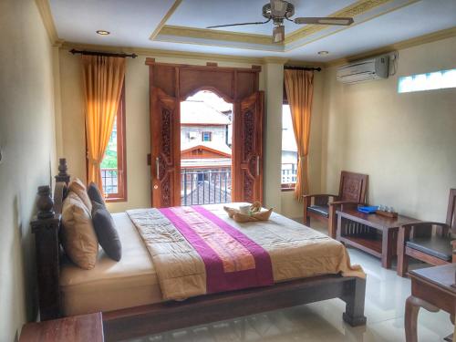 Un dormitorio con una cama grande y una ventana en Sapta House en Ubud