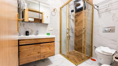 a bathroom with a shower and a sink and a toilet at Olive Branch Hotel in Ayvalık