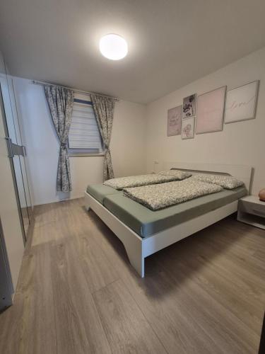 a bedroom with a bed and a wooden floor at Helle Wohnung im schönen Allgäu in Kraftisried